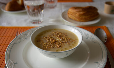 Delicious bowl of gourmet soup on a plate an a table