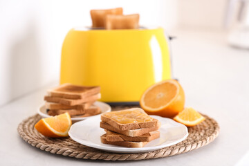 Modern toaster and delicious breakfast on table in kitchen