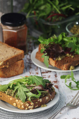 Homemade sandwiches with pesto, green salad and poached eggs
