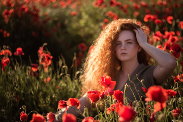 Naklejka premium Young beautiful red-hear girl in red poppy field