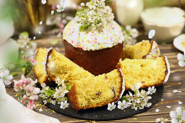 Сlosu-up оrthodox Easter cakes on the table. Wooden board brown background. Petals are flying. Happy Easter!