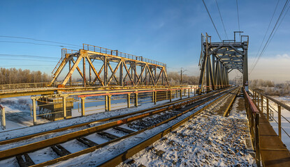 Winter landscape with a railway bridge over the Izhora river.