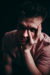 handsome young man thinks on a black background