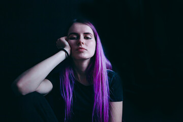 a girl with purple hair thinks on a black background