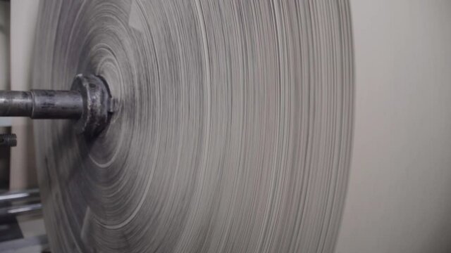 Automatic line for the production of micro-corrugated cardboard. A big babin is spinning. Creation of finished paper products. Packaging and printing. Industrial production