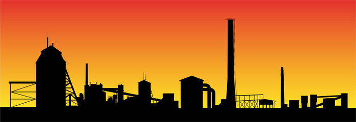 Oil shale processing plant silhouette on background of sunset. Long factory line with technical buildings and high chimneys.