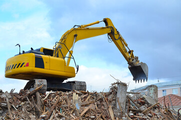 Obraz premium Building destruction, demolition of a building by an excavator