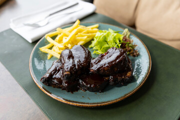 Sticky oven barbecue ribs served with french fries