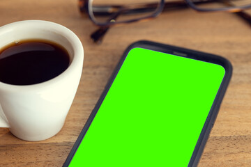 Smart phone on desk with green screen