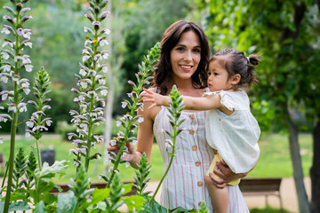 Mother looking away with charming smile holding kid on hands