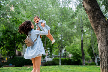 Obraz premium Happy woman embracing child in garden