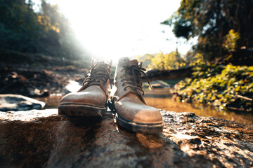 Leather boots on a rock in a natural stream.