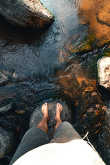 Feet in clear water in the forest