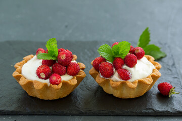 Wild strawberry tartlets with cream filling. delicious summer fruit mini tarts