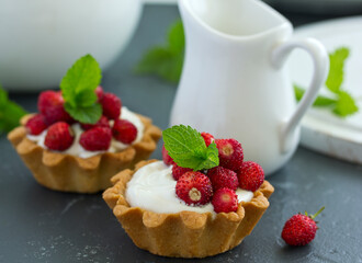 Wild strawberry tartlets with cream filling. delicious summer fruit mini tarts