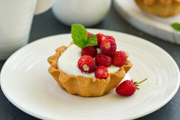 Wild strawberry tartlets with cream filling. delicious summer fruit mini tarts
