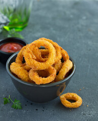 Homemade crunchy fried onion rings with tomato sauce