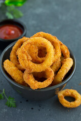Homemade crunchy fried onion rings with tomato sauce