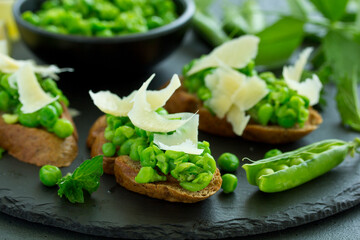 Crostini with pea puree, mint and parmesan. Snack.