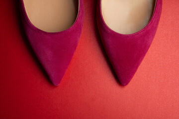 Women's shoes of red fuchsia color on a red background close-up. Abstract fashion.