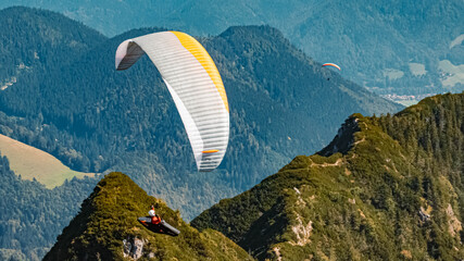Beautiful alpine summer view with a paraglider at the famous Hochfelln summit, Bergen, Bavaria,...