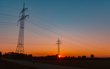 Fototapeta na wymiar Beautiful summer sunset with high voltage overhead lines near Aholming, Bavaria, Germany