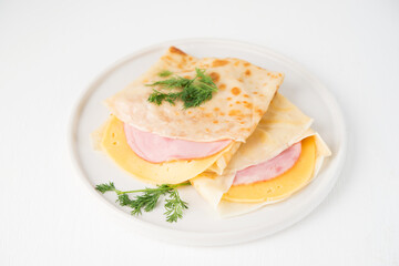 Homemade pancakes with ham and cheese on a white background, Maslenitsa, top view