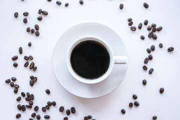 Flat lay of hot americano coffee in white coffee cup and coffee beans on white background with copy space 