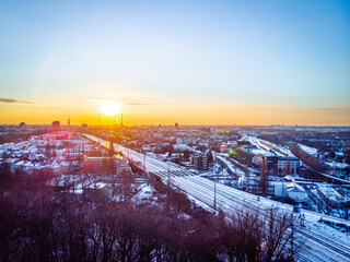 Fototapeta na wymiar View of the snow-covered skyline of Duisburg at sunset from above