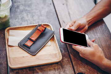 Business man hand use smartphone on wood table with ice green tea