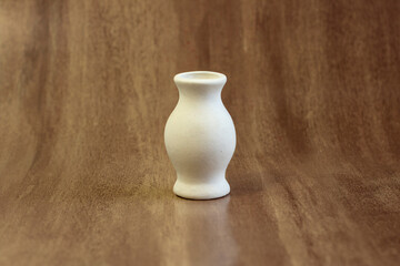 Small clay ceramic blank vases for painting close-up on a dark wooden background