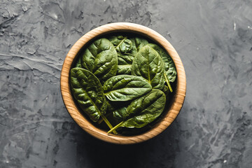 Obraz na płótnie Canvas Baby spinach leaves in bowl on grey concrete backgroundClean eating, detox, diet food ingredient