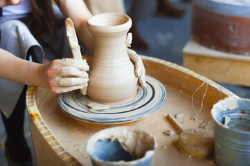 Making a jug from clay on a potter's wheel close-up.