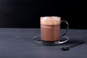 Frothy cocoa on the gray table. Hot sweet drink