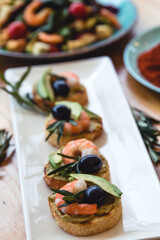 Appetizer canape with shrimp and cucumber on plate on table close up