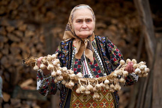 Old farmer woman with garlic rope