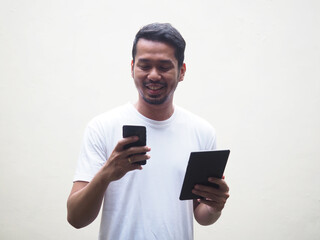 Man using mobile phone and tablet at the same time