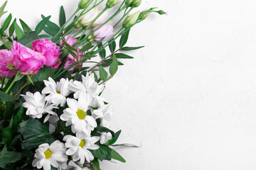Fresh flowers against the white background. Roses, eustomas, chrysanthemum and pistachio leaves. Copy space