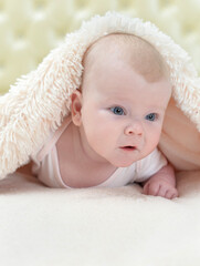 cute little baby girl playing under the blanket