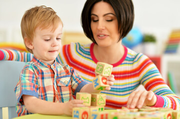 Woman and little boy playing with cubes