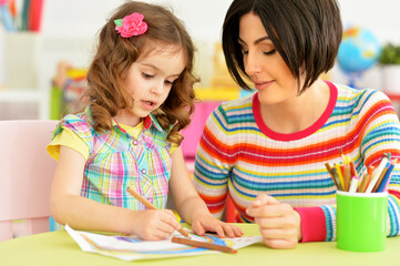 little cute girl with mother drawing