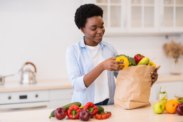 African Housewife Unpacking After Grocery Shopping Cooking In Modern Kitchen