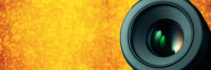Camera lens on yellow bright background with deep shadow. Top view. Flat lay. Minimalism