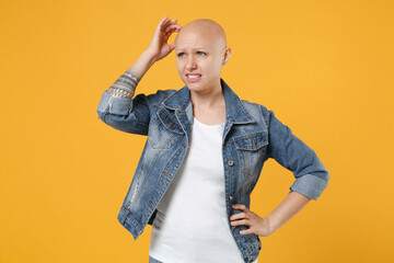 Young bald caucasian pensive thoughful troubled woman 20s without hair wearing casual denim jacket...