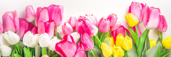 Spring tulip flowers background. White, yellow, pink, red tulip bouquet on white background with bokeh effect, banner mock up format
