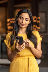 Fototapeta na wymiar Beautiful Asian Indian woman talking / texting on mobile phone