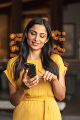 Beautiful Asian Indian woman talking / texting on mobile phone