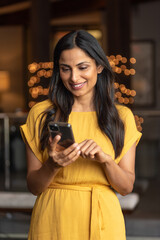 Beautiful Asian Indian woman talking / texting on mobile phone