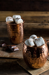 The dessert food vintage style : The Marshmallow with hot chocolate in copper cup on the wooden table. Background copy space for copy text