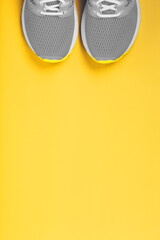 Sports gray sneakers on a yellow background - sport concept, free space.